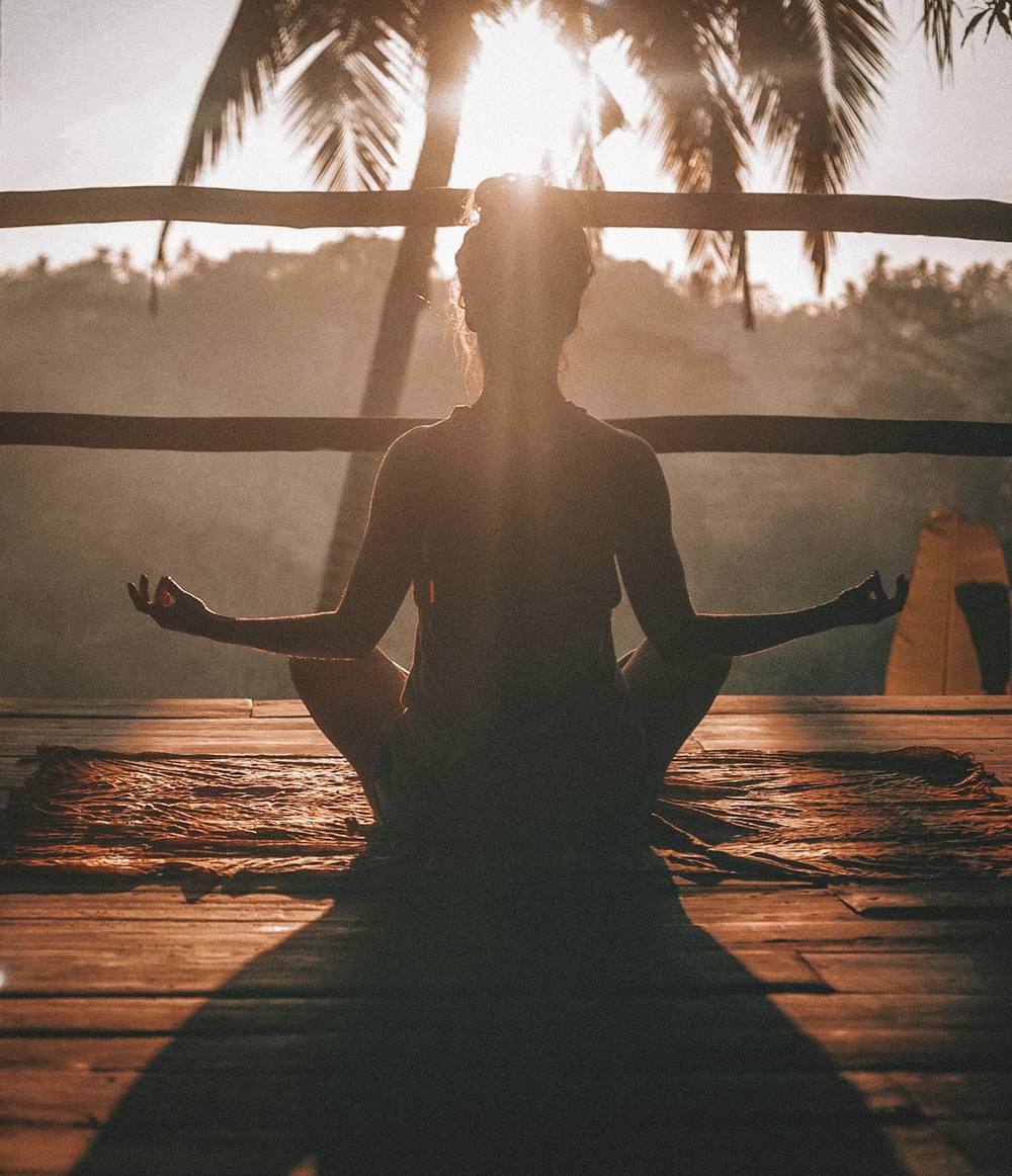 Femme en méditation au lever du soleil, apaisement du corps et de l'esprit